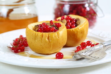 Baked apples with honey, walnuts, currants on a white background