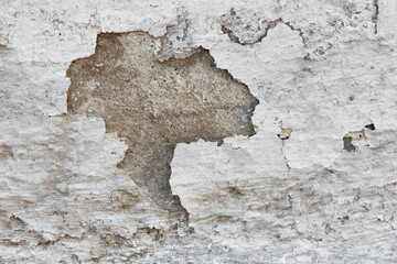 Background with wall texture with peeling old white paint.