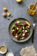 Fototapeta na wymiar Beetroot salad with cheese, arugula, nuts and honey. Healthy eating. Vegetarian food.