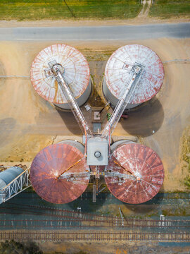 Looking down onto grain silos beside a road and railway line