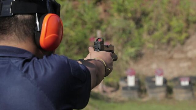 A man practice to do gun shot to target point in outdoor arena