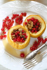 Baked apples with honey, walnuts, currants on a white background