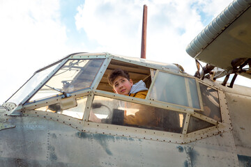 A young man on board an old abandoned Soviet plane. The guy looks out the window.