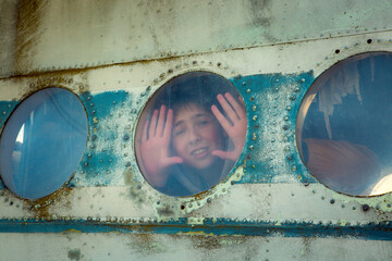 A young man on board an old abandoned Soviet plane. The guy looks out the window.