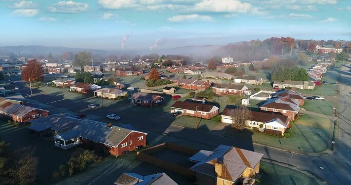 A forward rising aerial establishing shot of a typical Western Pennsylvania residential neighborhood on a frosty late-Autumn morning. Tilt up to sky. Pittsburgh suburbs.  	