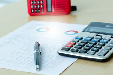 Close up calculator on paper charts ,red walky talky radio, workplace in office, selective focus. Working from home.