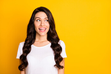 Photo of cute cunning young woman wear white t-shirt showing tongue looking empty space isolated...