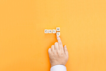 The male hand moves one of the letter cubes, turning the word Calm into Call