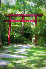 Red Torii gates and lacquered arched bridge in a Japanese zen  gardens. This park is the Friendship Park, a public garden located in Rueil-Malmaison in the Hauts-de-Seine in France.  