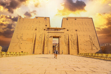 A young tourist entering the Temple of Edfu in the city of Edfu, Egypt. On the bank of the Nile...