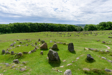 vertical view of the Viking burial grounds at Lindholm Hills under a blue sk with white clouds