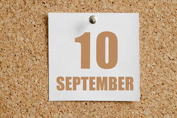 september 10. 10th day of the month, calendar date.White calendar sheet attached to brown cork...