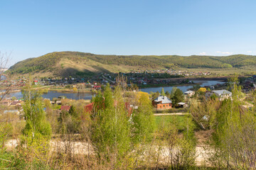 Fototapeta premium Small town on the background of the river and mountains.