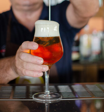 Camarero ofreciendo una cerveza reci&eacute;n echada.