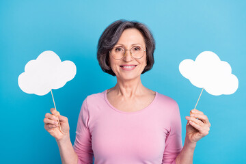 Photo of mature positive good mood beautiful mature woman hold paper cloud isolate on blue color...