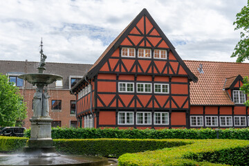 historic red half-timbered house and the Kayerod fountain in the old town city center of Aalborg