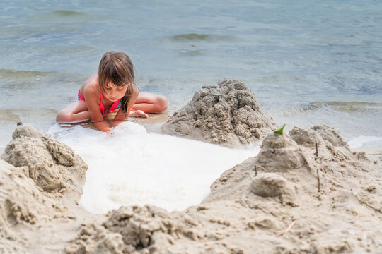 Portrait of beautiful young girl playing on sea beach. Summer holiday concept. Horizontal image.