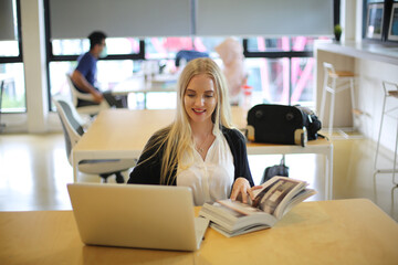 Obraz premium Female College Student Reading A Book In Library