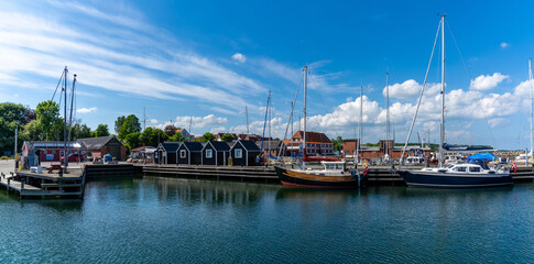 picturesque harbor and marina of Lundeborg on Funen island in Denmark with sailboats moored at the docks - obrazy, fototapety, plakaty