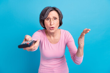 Fototapeta premium Photo of unhappy upset negative mood woman watch television hear bad news isolated on blue color background