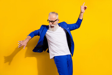 Photo portrait of senior man in blue suit dancing at party isolated bright yellow color background