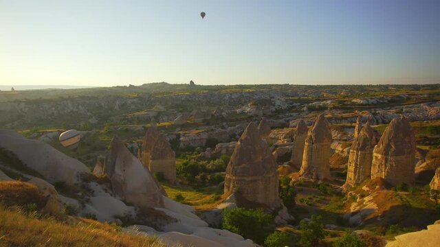Flying hot air balloons in morning sunny scenic volcanic rocky landscape of amazing Cappadocia, Turkey, Anatolia