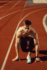 Obraz premium young guy with athletic body getting ready to run
