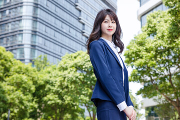 Beautiful Asian woman outdoors, wearing a suit