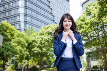 Beautiful Asian woman outdoors, wearing a suit