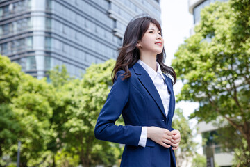 Beautiful Asian woman outdoors, wearing a suit