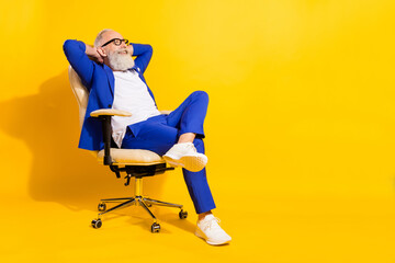 Full size photo of happy smiling businessman sit chair relaxing having break from work isolated on yellow color background