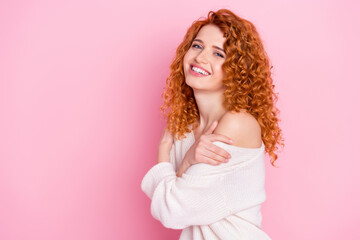 Photo portrait of red haired curly woman smiling laughing embracing herself isolated on pastel pink...