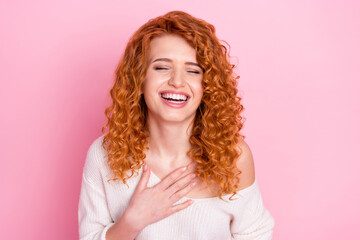 Photo portrait of red haired woman laughing keeping hand on chest isolated on pastel pink color...