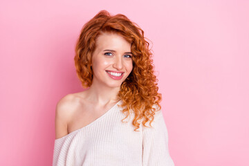 Photo portrait of red curly haired girl smiling wearing stylish sweater with off-shoulder isolated pastel pink color background