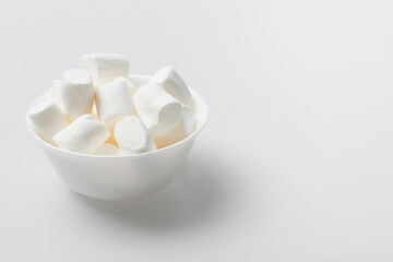 soft and puffy marshmallows in bowl on white