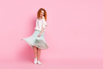 Full length body size photo of red hair woman smiling in skirt dancing spinning at party isolated on pastel pink color background