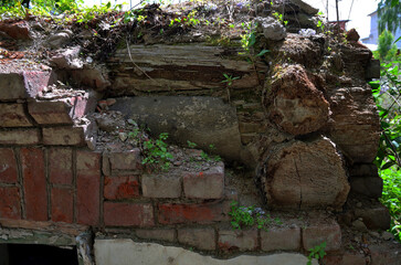 Destroyed wall of an old wooden log and brick house