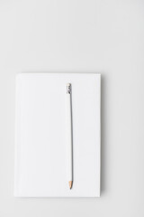top view of pencil on notebook in hardcover isolated on white