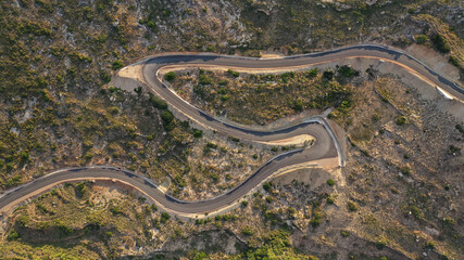 Aerial drone top down photo of serpentine winding asphalt road forming an 