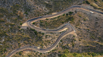 Aerial drone top down photo of serpentine winding asphalt road forming an 