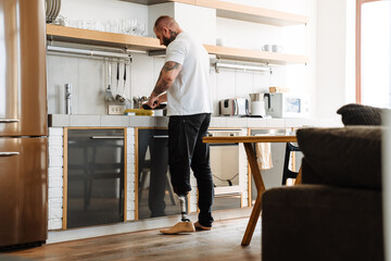 White man with prosthesis cooking lunch in kitchen at home