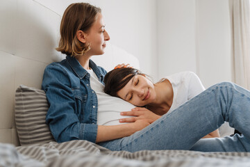 Close-up shot of smiling Leisby girls expecting a baby and lying on their belly