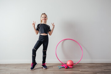 Young professional gymnast girl posing with equipment