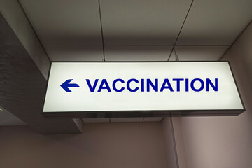 Blue arrow and the inscription "Vaccination" on the sign in the clinic.