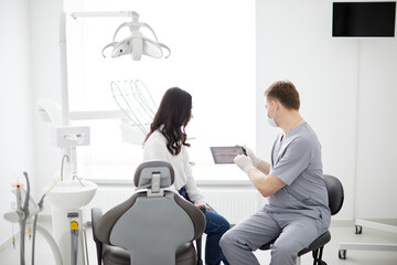 Male dentist with digital tablet. Modern treatment in professional dental clinic.