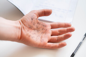 hand with formulas on the exam, cheating note on the palm during study