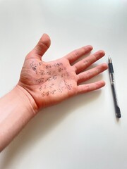 hand with formulas on the exam, cheating note on the palm during study