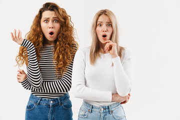 Young two women gesturing while expressing surprise at camera