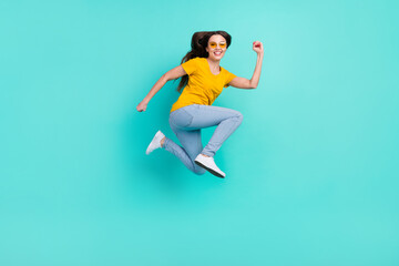 Fototapeta na wymiar Full body profile photo of funky young lady jump wear eyewear yellow t-shirt jeans isolated on teal color background