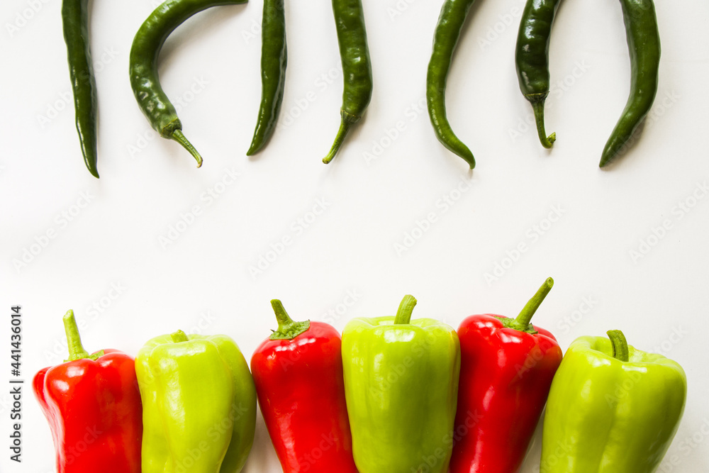 Wall mural top view of ripe green and red bell peppers and green chili peppers isolated on white background